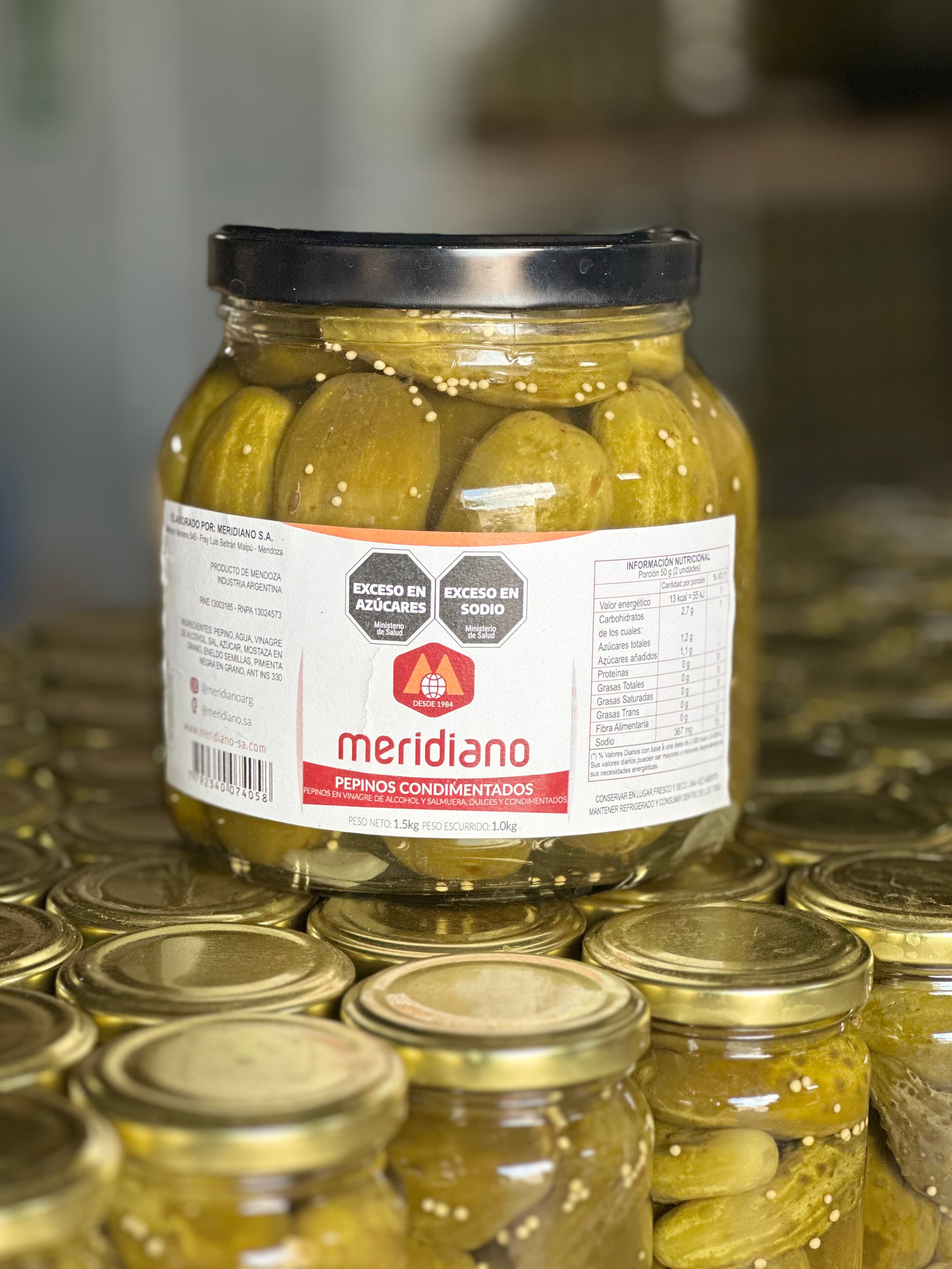 Frasco de pepinos condimentados Meridiano sobre línea de producción